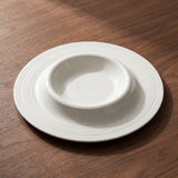 Solis Soup Plate — sculptural gallery view on a warm wood table