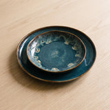 Spritz Irregular Dinnerware Set — deep blue reactive plates on a warm wood table