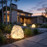 Garden Stone Outdoor Light glowing among garden planting at dusk