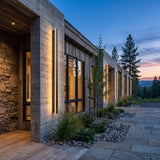 A run of Outdoor Sleek Wall Light along a house facade at dusk