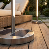 Outdoor floor lamps lining a pool at dusk