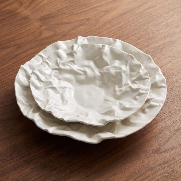 Kajabi Plate Collection — sculptural crumpled white ceramic plates on walnut