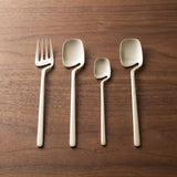 Supreme Cutlery Set — brushed steel flatware on a warm wood table
