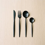 Spain Set — matte black flatware on a warm wood table