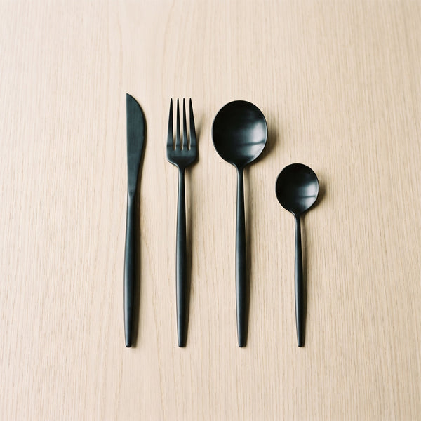 Spain Set — matte black flatware on a warm wood table