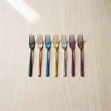 Milan Fruit Fork — jewel-toned fruit forks on a warm wood table