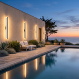 Stripe Lined Wall Lights on a pool house wall, reflected in the water at dusk