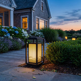 Cage Post Light (Outdoor Solar) glowing among garden planting at dusk