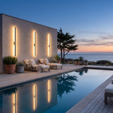 Outdoor Sleek Wall Light mounted on a pool house wall, reflected in the water at dusk