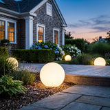 Element Lamp glowing among garden planting at dusk