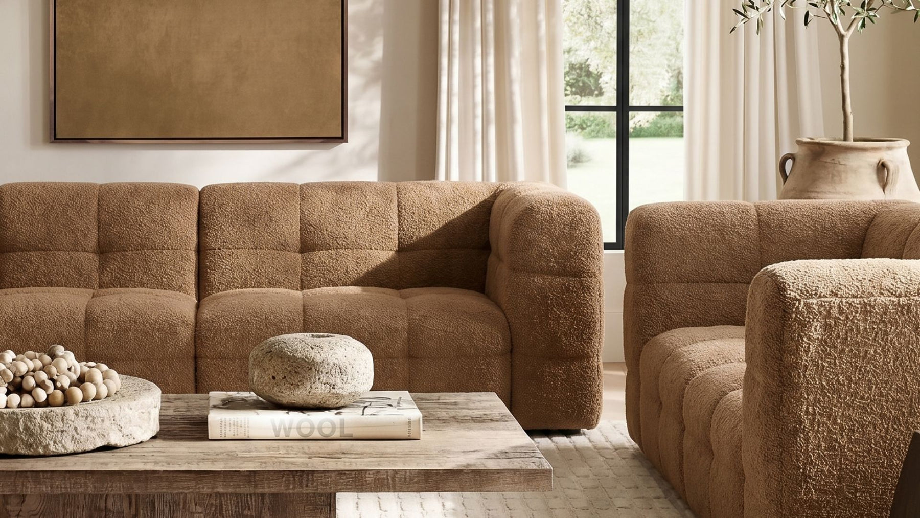 A cognac bouclé Puff chaise beside a fireplace with an ocean view